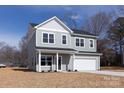 Two-story home featuring a two-car garage, green door, gray siding, and a manicured lawn at 116 Durham Rd, Stanley, NC 28164