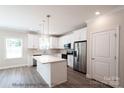 Modern kitchen with white cabinets, quartz countertops, and stainless steel appliances at 116 Durham Rd, Stanley, NC 28164