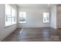 Light-filled living room with wood-look floors, large windows offering ample sunlight, and a white interior at 116 Durham Rd, Stanley, NC 28164