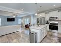 Open-concept kitchen with white cabinets, stainless steel appliances, flowing into the adjacent living area at 1244 Scotch Meadows Loop, Monroe, NC 28110