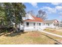 White house with red roof, front porch, and landscaped yard at 1712 S Main St, Salisbury, NC 28144