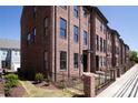 Brick townhomes with black-framed windows and black doors, surrounded by a low wrought iron fence at 216 Gilead Rd, Huntersville, NC 28078