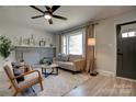 Bright living room with a stone fireplace, large window, comfortable seating, and light wood flooring at 2624 Ashley Rd, Charlotte, NC 28208