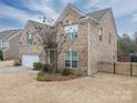 Two-story brick home with a white garage door and landscaped yard at 2748 Smethwick Ln, Gastonia, NC 28056