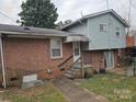 Brick and light blue vinyl siding home with steps leading to a back door at 3219 Sutton Dr, Charlotte, NC 28216