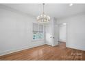 Bright bedroom with hardwood floors, a window and stylish chandelier lighting at 357 Magnolia St, Davidson, NC 28036