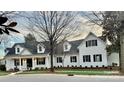 Charming white brick home featuring a well-manicured lawn and beautiful landscaping at 357 Magnolia St, Davidson, NC 28036