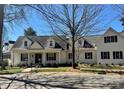 Lovely two-story white brick home with black shutters on a sunny day with a well-kept lawn at 357 Magnolia St, Davidson, NC 28036