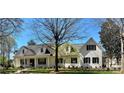 Charming painted brick home featuring a covered porch, manicured lawn, and well-maintained landscaping at 357 Magnolia St, Davidson, NC 28036