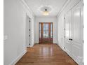 Elegant foyer with gleaming hardwood floors, chandelier lighting and a wood front door with glass inserts at 357 Magnolia St, Davidson, NC 28036