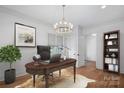 Elegant office with a wooden desk, chandelier lighting, hardwood floors, and a comfortable workspace at 357 Magnolia St, Davidson, NC 28036