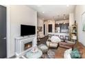 Open-concept living room flows to kitchen featuring a decorative fireplace and modern furnishings at 3630 N Davidson St # 4406, Charlotte, NC 28205