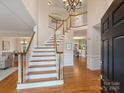 Grand foyer with hardwood floors, a soaring ceiling, a staircase, and elegant chandelier at 6042 Legacy Cir, Charlotte, NC 28277