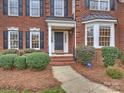 Inviting front entrance showcasing a covered porch, brick steps, and manicured landscaping at 6042 Legacy Cir, Charlotte, NC 28277