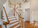 Elegant staircase showcasing wood treads, white risers, and a decorative banister at 6042 Legacy Cir, Charlotte, NC 28277