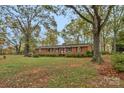 Inviting brick home with a well-manicured lawn and mature trees offering a peaceful setting at 725 Plantation Rd, Lancaster, SC 29720