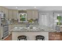 A stylish island with granite countertops and barstool seating in the eat-in kitchen at 725 Plantation Rd, Lancaster, SC 29720