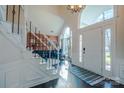 Bright foyer with high ceilings, hardwood floors, staircase and transom window above the front door at 7505 Torphin Ct, Charlotte, NC 28269