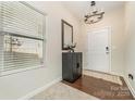 Inviting entryway with gleaming hardwood floors, a stylish light fixture, and a convenient cabinet for storage at 8411 Washoe Pine Ln, Charlotte, NC 28215