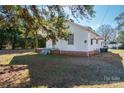 Cozy single-story home featuring a quaint front porch, brick foundation, well-kept lawn, and mature shade trees at 105 W 21St St, Kannapolis, NC 28081