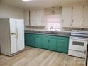 Kitchen with teal cabinets, granite counters, and white appliances at 105 W 21St St, Kannapolis, NC 28081