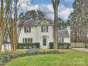 Well-maintained two-story home with white brick, a stone accent, and manicured lawn and garden at 11143 Coachman Cir, Charlotte, NC 28277