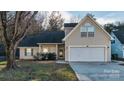 A cozy home featuring neutral siding, an attached two-car garage, and mature landscaping at 12016 Regent Ridge Ln, Charlotte, NC 28278