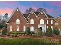 Beautiful brick home at sunset, showcasing a well-manicured lawn and elegant design at 1604 Windy Ridge Rd, Charlotte, NC 28270