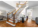 Elegant foyer showcasing hardwood floors, staircase with decorative iron railings, and bright lighting at 1604 Windy Ridge Rd, Charlotte, NC 28270