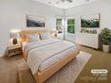 Virtually staged bedroom with light wood platform bed and dresser at 1633 Barroso Ln, Charlotte, NC 28213