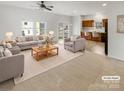 Virtually staged living room with gray sofas and a wooden coffee table at 1633 Barroso Ln, Charlotte, NC 28213