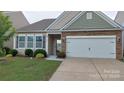 Beautiful single-Gathering home boasting stone accents, a two-car garage, and lush green landscaping at 164 N Cromwell Dr, Mooresville, NC 28115