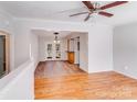 Bright, open-concept living space with hardwood floors, ceiling fan, and elegant lighting at 3029 Winding Trl, Matthews, NC 28105