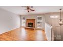 Inviting living room featuring a brick fireplace, hardwood floors, and sunlit windows at 3029 Winding Trl, Matthews, NC 28105