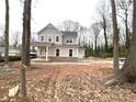 Two-story house with gray siding, brick base, and a two-car garage; wooded lot at 553 W Lowrance Ave, Mooresville, NC 28115