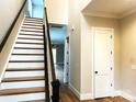 Bright foyer with staircase featuring wood treads, white risers, and dark wood railing at 553 W Lowrance Ave, Mooresville, NC 28115