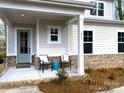 Inviting front porch with seating area, brick accents, and a stylish blue front door at 553 W Lowrance Ave, Mooresville, NC 28115