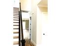 Wooden staircase with dark railing, leading to an open living area at 553 W Lowrance Ave, Mooresville, NC 28115