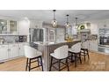 Spacious kitchen with granite island, white cabinets, and stainless steel appliances at 8478 Rocky River Rd, Harrisburg, NC 28075