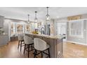 Modern kitchen featuring a large island with seating and granite countertops at 8478 Rocky River Rd, Harrisburg, NC 28075