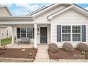 Inviting front porch featuring a cozy bench and well-maintained landscaping at 8714 Summer Serenade Dr, Huntersville, NC 28078