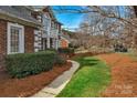 Beautifully landscaped front yard with lush greenery, decorative shrubbery, and a charming walkway at 10417 Sutherby Dr, Charlotte, NC 28277