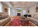 Bright living room featuring hardwood floors, decorative fireplace, tray ceiling and comfortable neutral-toned sofas at 105 Plantation Ct, Shelby, NC 28150