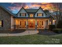 Stunning home exterior with a covered porch featuring rocking chairs, stone accents, and double front doors at 134 Wild Harbor Rd, Mooresville, NC 28117