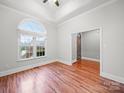 Bright living room with large arched window, hardwood floors, ceiling fan, and neutral paint tones at 209 Chesterfield Canal None, Fort Mill, SC 29708