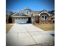 Brick home with three-car garage and landscaped front yard at 2108 Cadence Trace Dr, Mint Hill, NC 28227