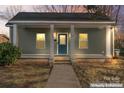 Charming home featuring a covered porch, blue front door and well maintained lawn at 309 Lloyd St, Salisbury, NC 28144