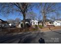 Houses on a tree lined street, with gray siding and red brick at 315 S Hill St, Gastonia, NC 28052