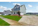 Two-story house exterior with blue and green siding, landscaping and driveway at 3915 Allenby Pl, Monroe, NC 28110