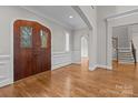 Inviting foyer with a wood front door, hardwood floors, and white trim at 4008 Quintessa Dr, Matthews, NC 28104